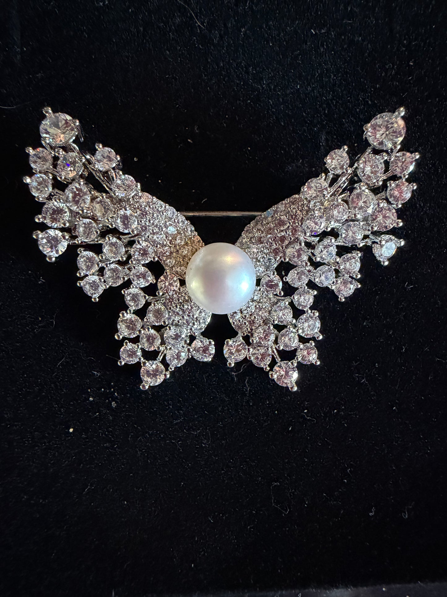 Plated butterfly broach with cubic zirconia and a white button pearl